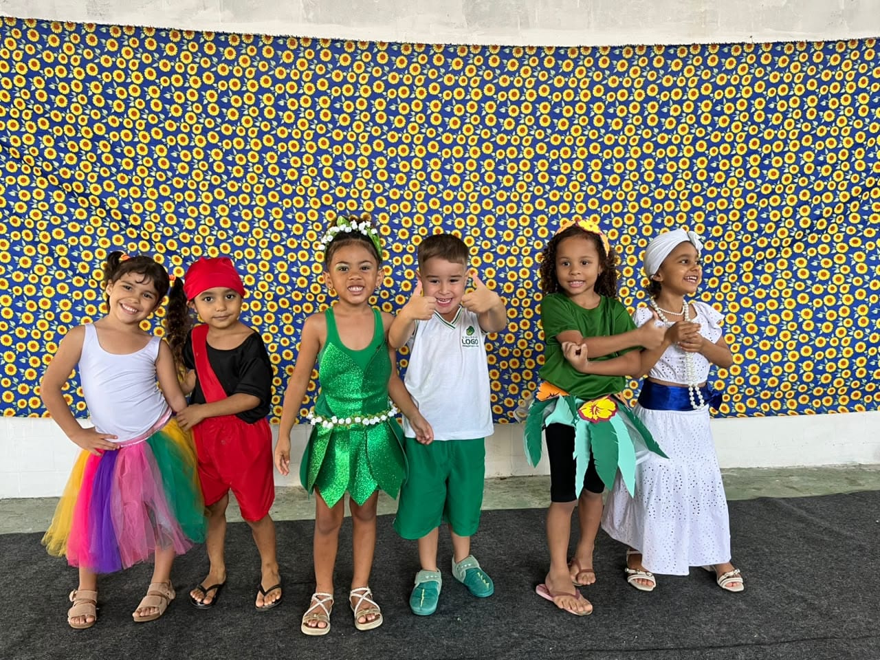 Crianças em fantasias coloridas, lado a lado