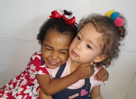 Duas alunas do Colégio Logo abraçadas, sorrindo
